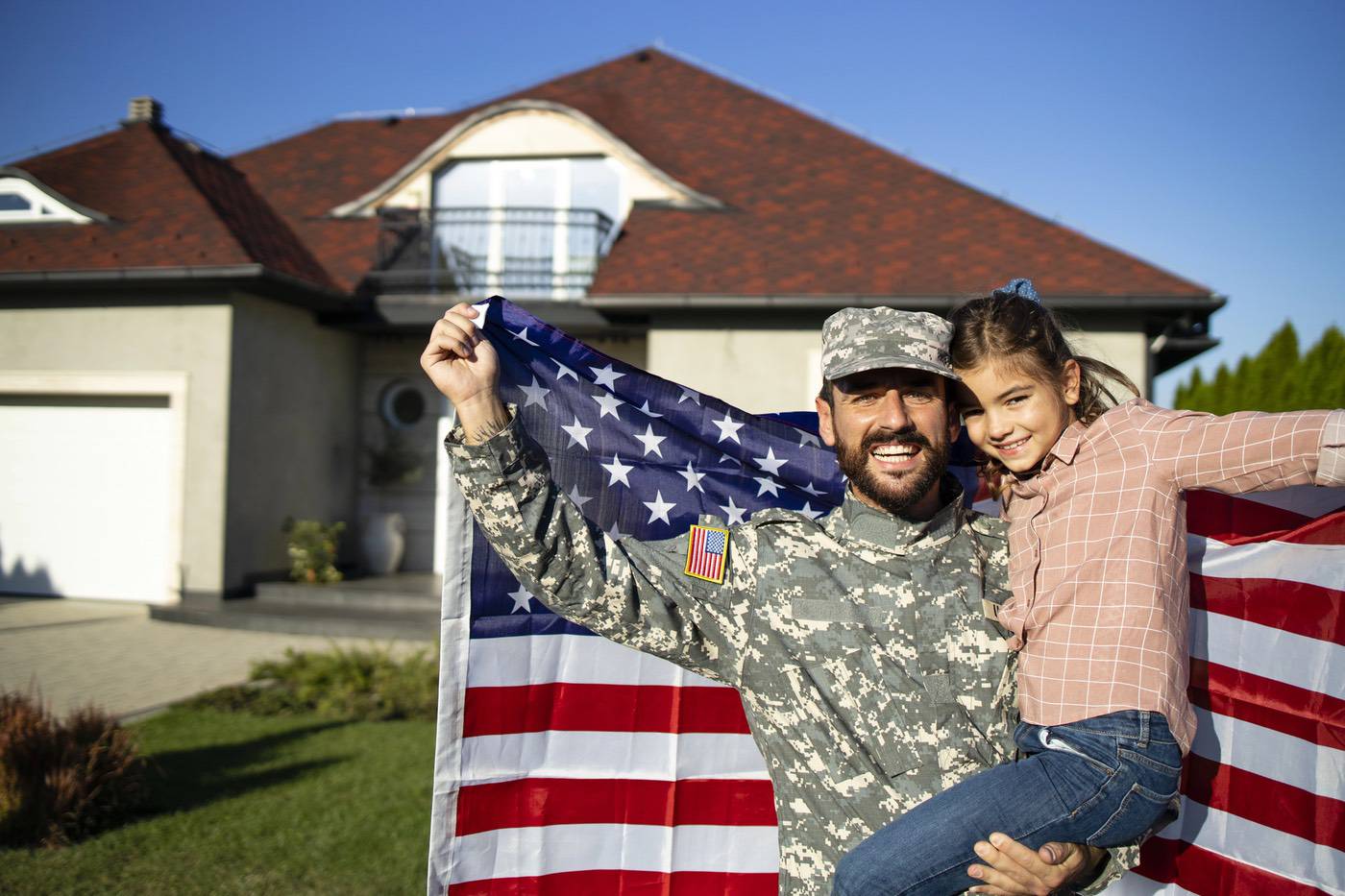 Veteran and spouse smiling outside their new Colorado home.