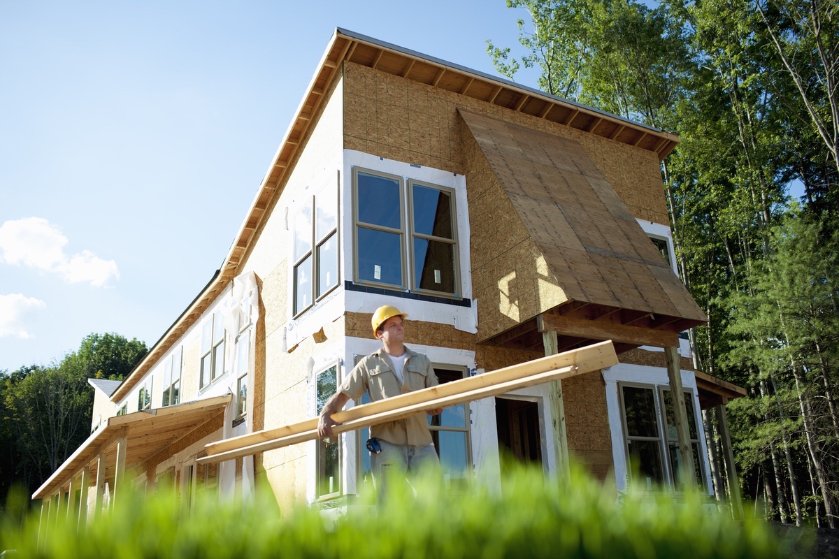 Crew framing a new single-family home under blue skies.