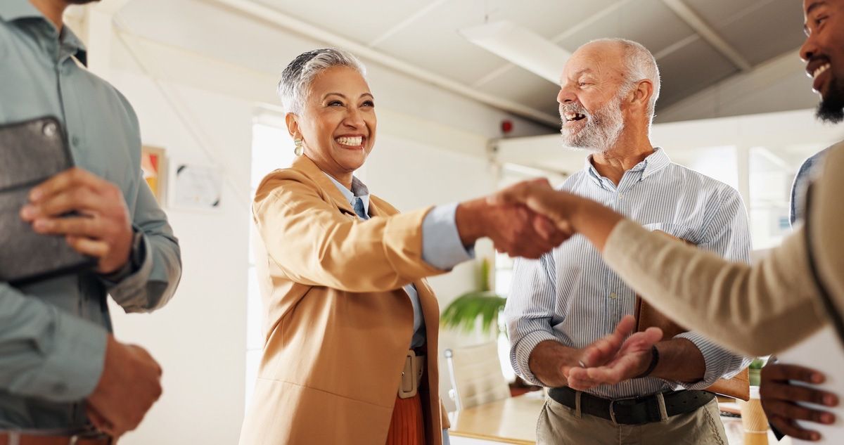 Mortgage professional celebrating clients with a handshake.