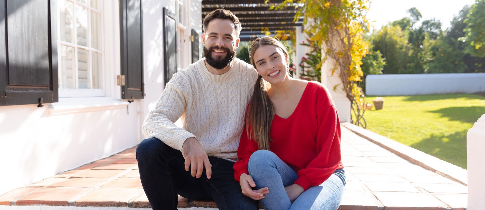 Happy couple sitting on their patio discussing finances.