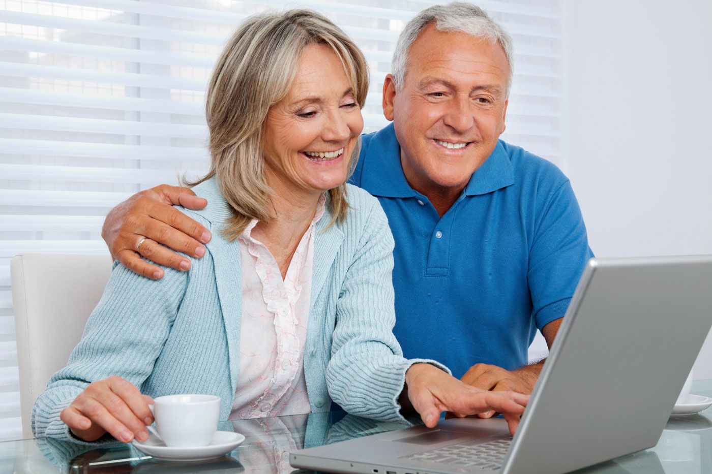 Senior couple holding keys after unlocking home equity.
