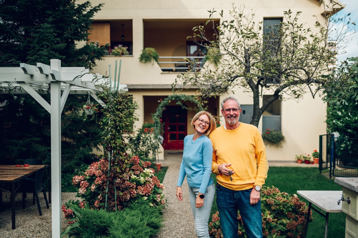 Senior couple holding keys after unlocking home equity.